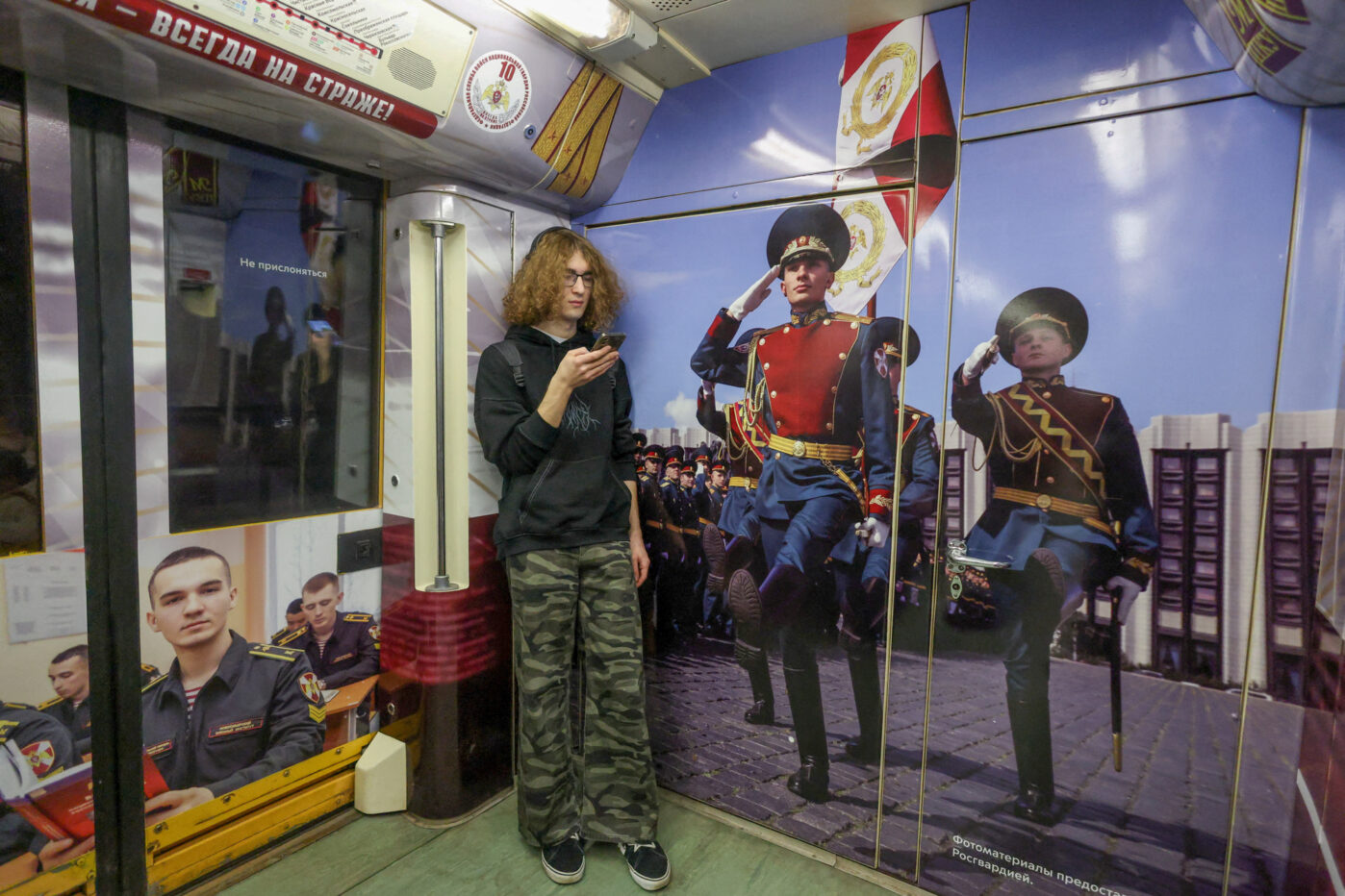Пассажир метро разговаривает по&nbsp;мобильному телефону в&nbsp;тематическом поезде Росгвардии в&nbsp;Москве